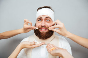 Frightened scared bandaged man taking pills from doctors hands