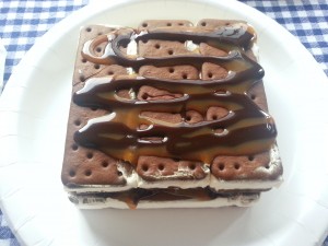 Make your own ice cream cake using ice cream sandwiches, chocolate sauce, caramel and cool whip for an easy, delicious treat | Ice Cream Sandwich Cake