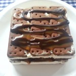 Make your own ice cream cake using ice cream sandwiches, chocolate sauce, caramel and cool whip for an easy, delicious treat | Ice Cream Sandwich Cake