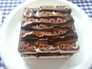 Make your own ice cream cake using ice cream sandwiches, chocolate sauce, caramel and cool whip for an easy, delicious treat | Ice Cream Sandwich Cake