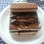 Make your own ice cream cake using ice cream sandwiches, chocolate sauce, caramel and cool whip for an easy, delicious treat | Ice Cream Sandwich Cake