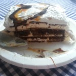 Make your own ice cream cake using ice cream sandwiches, chocolate sauce, caramel and cool whip for an easy, delicious treat | Ice Cream Sandwich Cake