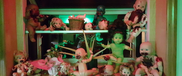 The green glow from the house and the red illumination from the light over the sink made these creepy baby dolls in kitchen window even worse