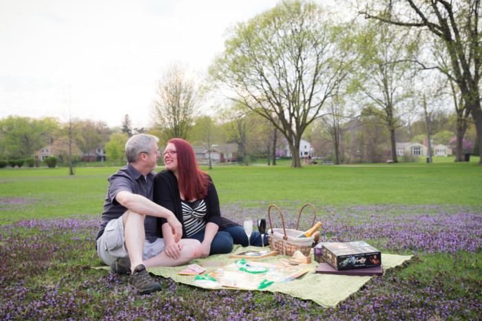 engagement photo shoot picnic with cheese, champagne, and games in a park