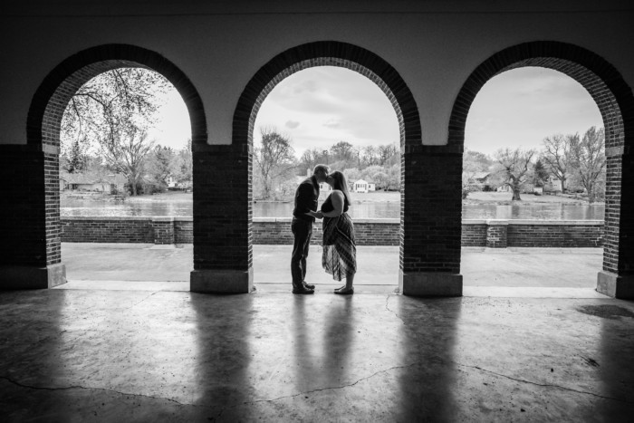 black and white silhouette engagement photo under archway