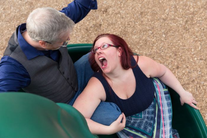 engagement photo session at a playground on the slide