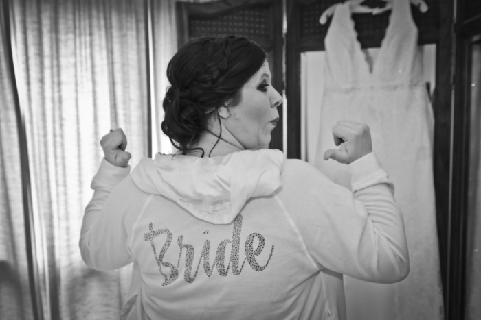 Pointing at my awesome bride hoodie in front of my tri-fold mirror where my wedding dress hung was one of my favorite photos.