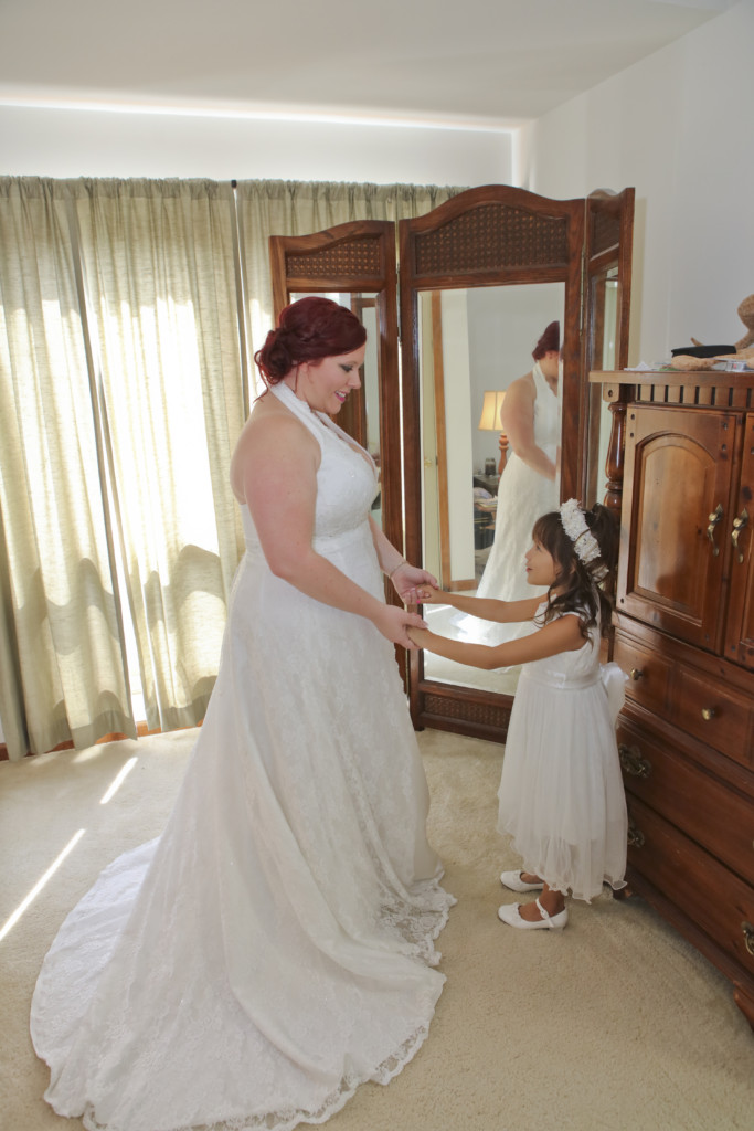 bride and flower gir bridal photo in front of a tri-fold mirror in bride's bedroom