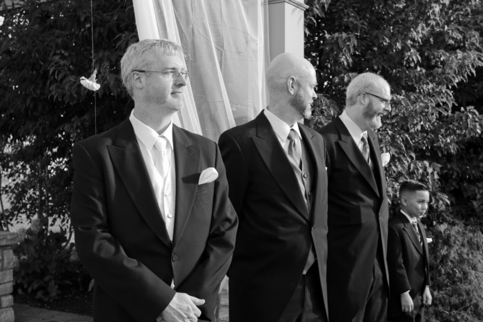 the groom, groomsmen, and junior groomsman at the alter