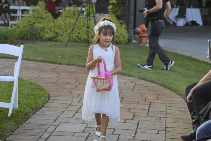 The flower girl threw pink rose petals