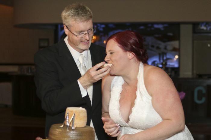 Taking a bite out of a big hunk of cheese makes for an awesome cake cutting ceremony at a wedding.