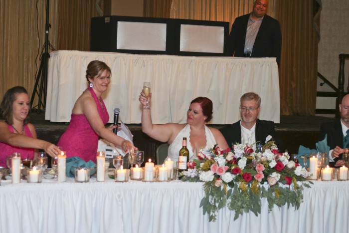 raising a glass at the head table at our wedding