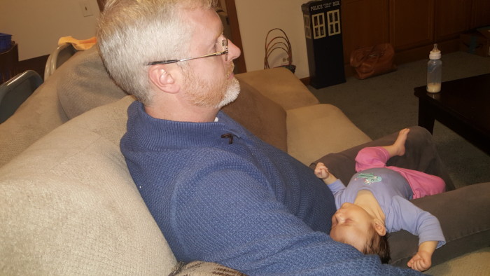 Baby laying in her uncle's lap