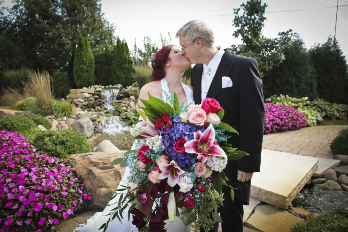 bride and groom kissing behind huge bridal bouquet