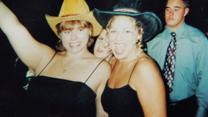 Two cheerleaders at the Glenbard East High School Homecoming dance 2000 in formalwear and cowboy hats.