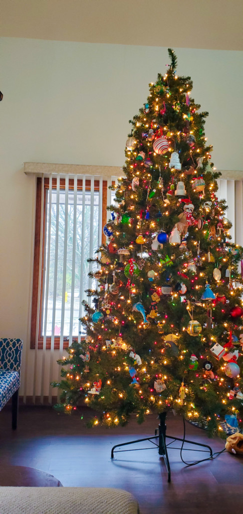 9-foot Christmas tree decorated with white and colored lights and ornaments