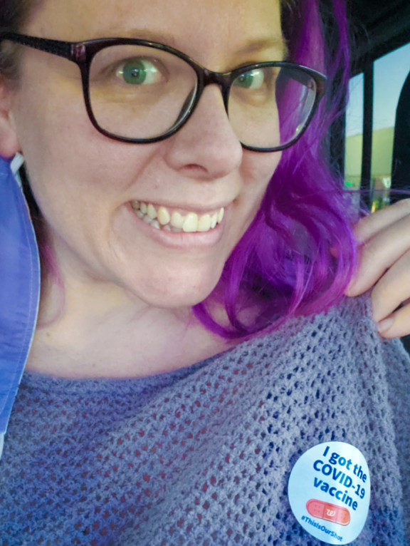 Chrissy Smiling and showing her Covid-19 vaccine sticker