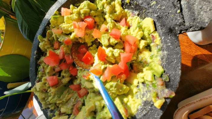 Guacamole in a stone molcajete with tomatoes